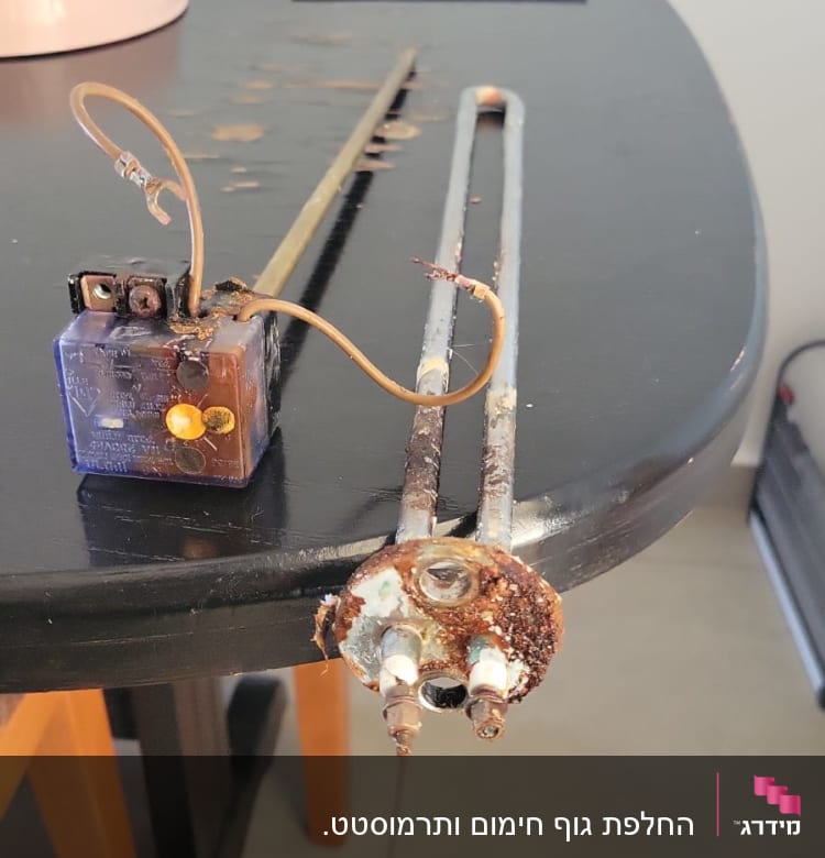 גוף חימום דודי שמש עם חלודה וחוטי חשמל